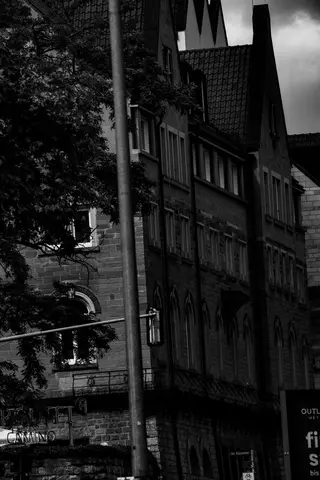 Fußgängerzone als schmale Schlucht; hohe Fassaden drücken den Raum zusammen.